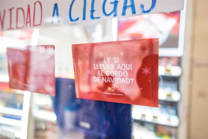 Un cartel en el que se lee '¿Y si llevas a quí el gordo de navidad?', pegado en la cristalera de la administración de lotería 'Los conejeros de la suerte' en Arrecife, Lanzarote, donde se vendieron los números 00750, premiado con el Tercer Premio y el 7