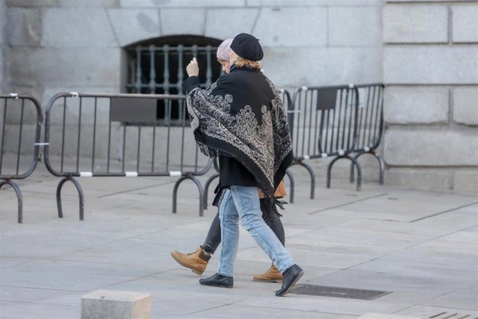 Una mujer se abriga con un poncho durante un día de viento por Madrid (España), a 8 de noviembre de 2019.