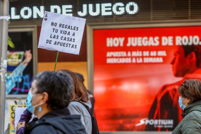 Una persona sostiene una pancarta donde se lee que "No regales tu vida a las casas de apuestas" en una manifestación contra la proliferación de los locales de apuestas que ha tenido lugar en el barrio madrileño de Carabanchel.