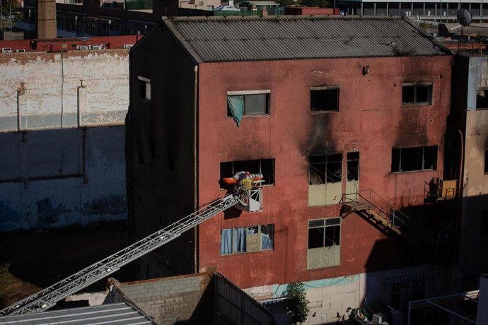 Bomberos retiran el cadáver de una de las personas fallecidas en el incendio de ayer en la nave okupada del barrio de Gorg, en Badalona, Barcelona, Catalunya (España), a 10 de diciembre de 2020.  