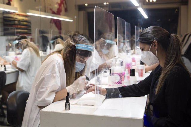 Mujeres con mascarilla en un taller de manicura en Tel Aviv, Israel