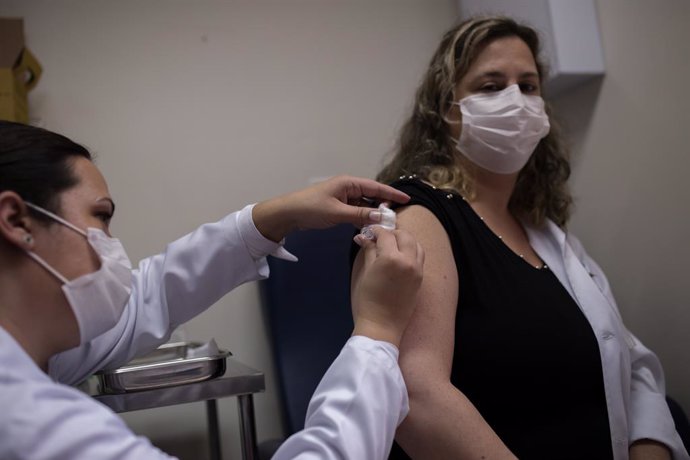 30 July 2020, Brazil, Sao Paulo: A volunteer at the Emilio Ribas Institute for Infectiology receives a newly developed coronavirus vaccine as part of its third testing phase by Chinese pharmaceutical company Sinovac. Photo: Andre Lucas/dpa