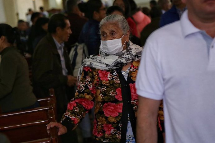 15 March 2020, Colombia, Bogota: An elderly woman wearing a face mask as she attends a mass in a church amid the coronavirus (COVID-19) outbreak. Coronavirus has now spread to 17 of the 20 Latin American countries. Photo: Camila Diaz/colprensa/dpa