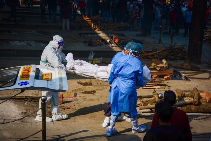 Trabajadores sanitarios trasladan el cadáver de una víctima del coronavirus en Nueva Delhi