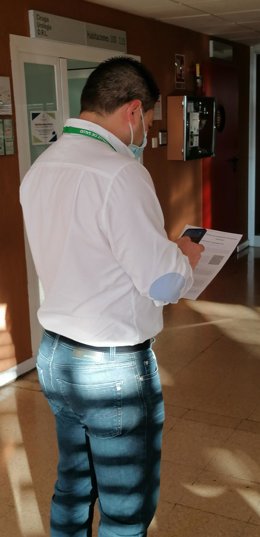 Un hombre consulta el código QR del sistema de información.