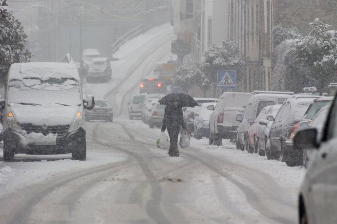 Un hombre camina en medio de una gran nevada en Becerrea, en Lugo.