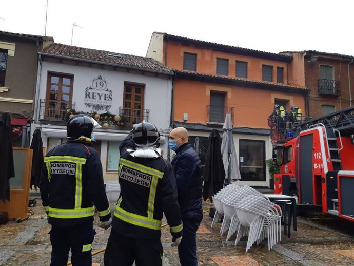 El alcalde de León, José Antonio Diez, junto a los bomberos que sofocaron el incendio de un restaurante en la plaza de San Marcelo de la ciudad.