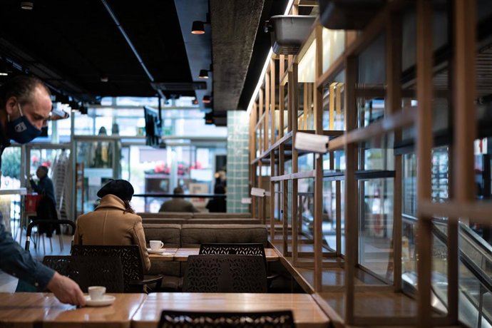 Un camarero limpia una mesa en un establecimiento de Vitoria 