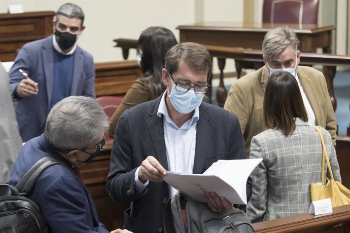 El portavoz económico del PSOE, Iñaki Álvaro Lavandera, departe con el consejero de Hacienda, Román Rodríguez, en un Pleno del Parlamento