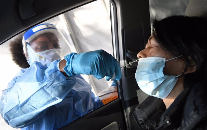 08 December 2020, US, Orlando: A medical worker takes a nasal swab from a woman at a rapid coronavirus (COVID-19) test site. Photo: Paul Hennessy/SOPA Images via ZUMA Wire/dpa