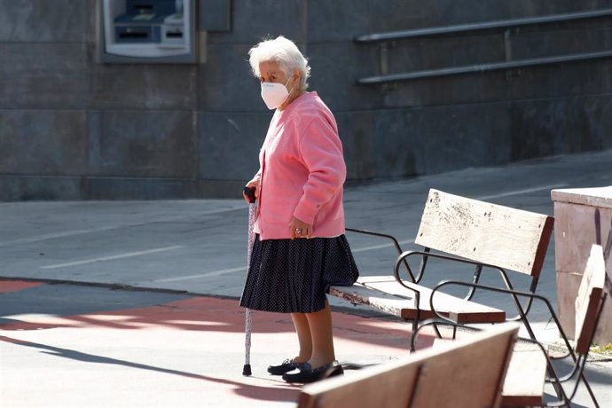 Una anciana camina por una calle de Valleaguado, Coslada, Madrid (España).