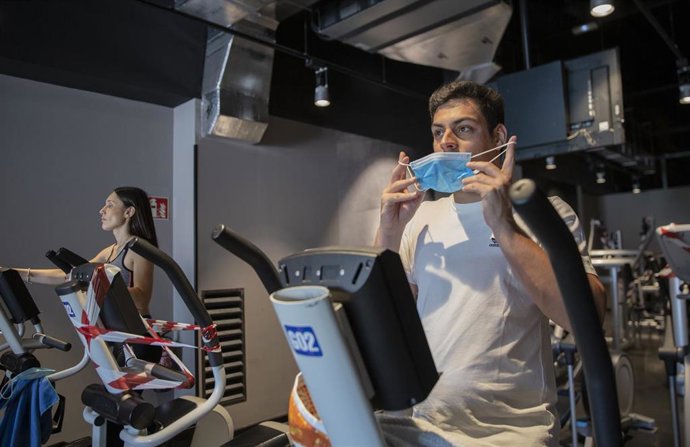 Dos personas hacen ejercicio en el gimnasio McFit durante el primer día de la fase 3, donde se permite la reapertura de gimnasios con el 50 % del aforo y manteniendo las medidas de seguridad. En Sevilla,(Andalucía, España), a 08 de junio de 2020.