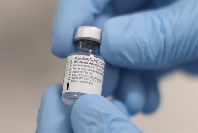 08 December 2020, Northern Ireland, Belfast: A person holds a phial of the Pfizer/BioNTech Covid-19 vaccine ahead of being administered at the Royal Victoria Hospital 
