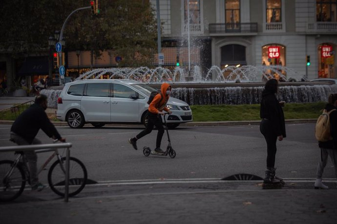 Un hombre en bici y un joven en patinete, Catalunya (España), a 10 de noviembre de 2020.   La propuesta de Plan de Movilidad Urbana (PMU) de Barcelona plantea que en 2024 un 81,52% de los desplazamientos se hagan a pie, en transporte público o en bicicl