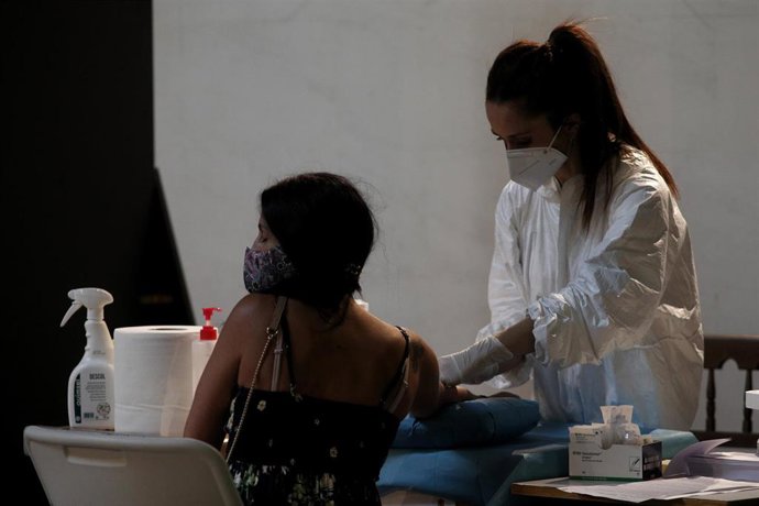 Una sanitaria saca sangre a una mujer