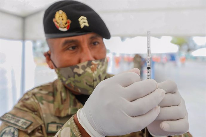 HANDOUT - 15 December 2020, Peru, Lima: An officer learns how to handle a vaccination. Armed forces will support health personnel in the Coronavirus vaccination campaign. Photo: Karel Navarro/Minsa/dpa - ACHTUNG: Nur zur redaktionellen Verwendung und nu