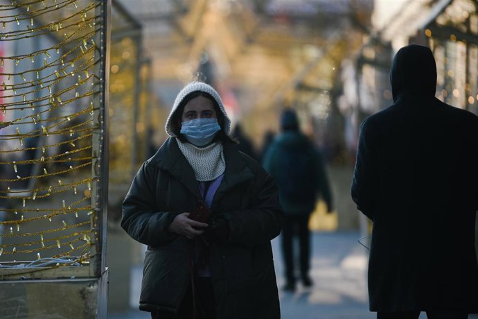 Una mujer con mascarilla pasea por Moscú