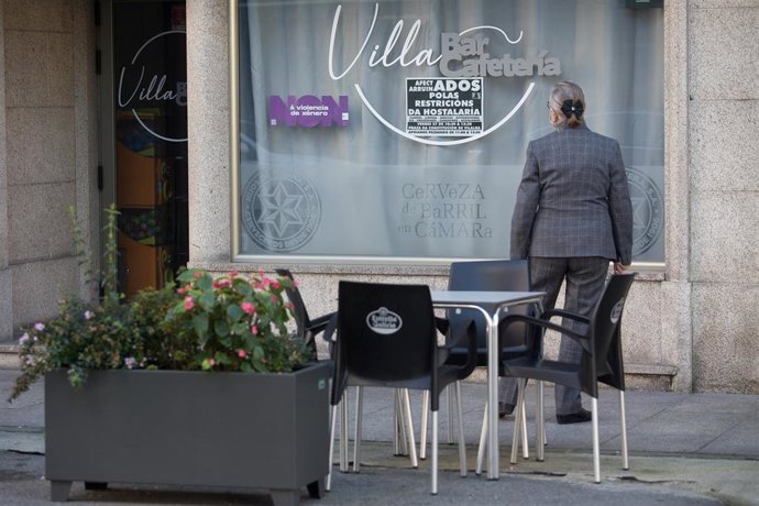 Un hombre observa un establecimiento cerrado el mismo día de la entrada en vigor de nuevas restricciones impuestas por la crisis del Covid-19 en el municipio, en Vilalba, Lugo, (España), a 21 de noviembre de 2020. 