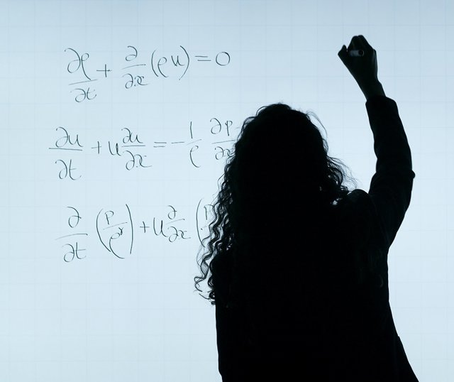 Profesor escribe en la pizarra.