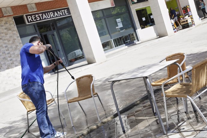 Un trabajador desinfecta la terraza de un restaurante antes de reabrir sus puertas el próximo lunes 25 de mayo, cuando Madrid pase a fase 1 de desescalada ante la crisis sanitaria del Covid-19. En Valdemoro, Madrid, a 23 de mayo de 2020