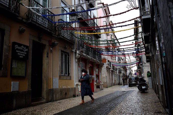 Una mujer con mascarilla pasea por Lisboa