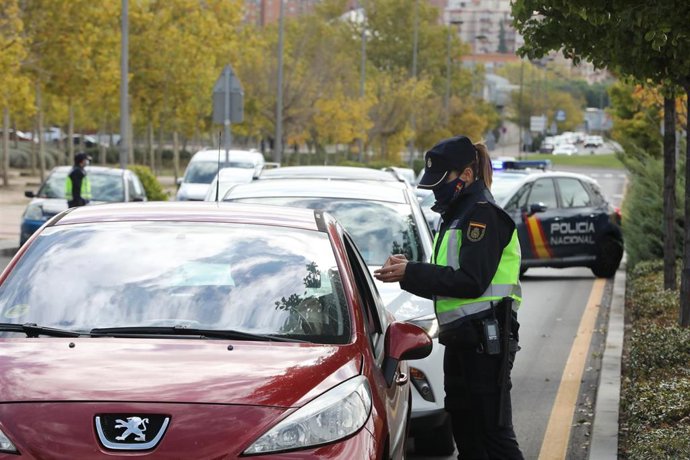Una agente de la Policía Nacional comprueba la documentación de un conductor durante un control policial en el segundo día de entrada en vigor de las nuevas restricciones de movilidad en el municipio madrileño de Alcorcón