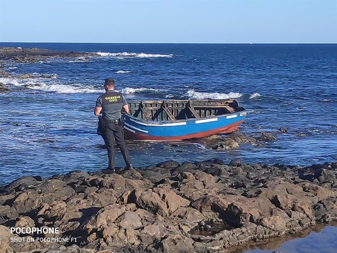 Un agente de Guardia Civil frente a una patera