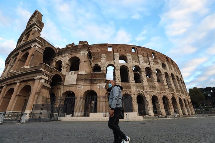 Un home amb mascareta passeja davant del Coliseu.
