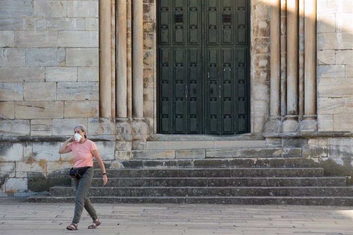 Una peregrina junto a la Iglesia de San Nicolao mientras los peregrinos retornan al Camino francés de la Ruta Jacobea casi un mes después del fin del estado de alarma por el coronavirus, en Portomarín, Galicia (España) a 15 de julio de 2020.