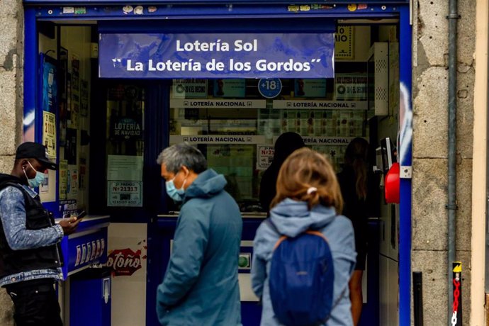 Varias personas hacen cola en las inmediaciones de la administración de lotería Sol donde venden boletos para el Sorteo Extraordinario de la Lotería de Navidad 2020, en Madrid (España), a 4 de noviembre de 2020. 