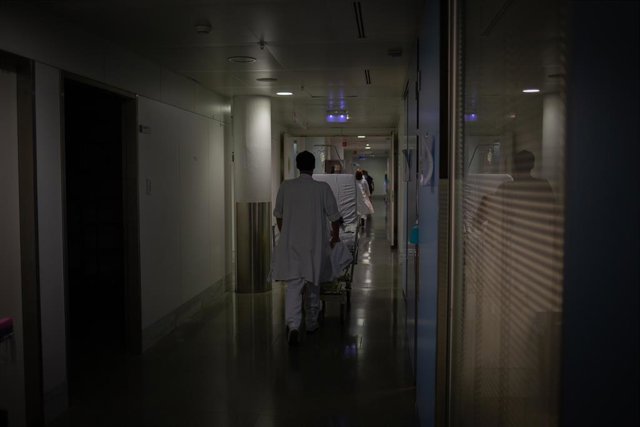Professional sanitari trasllada un llit mòbil a la unitat de vigilància intensiva (Arxiu)