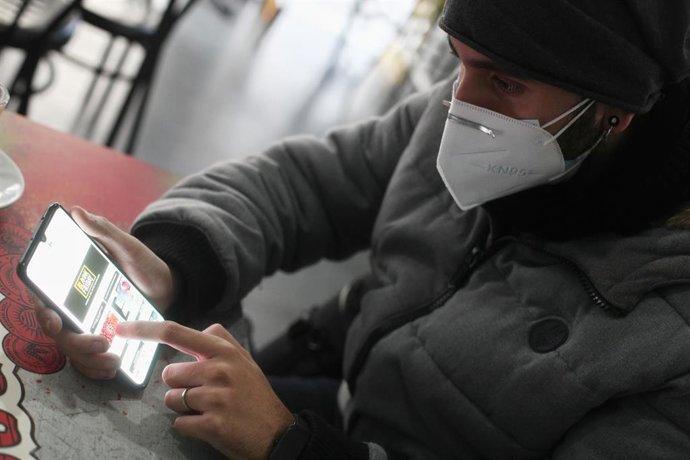 Un joven consulta las ofertas de Black Friday de un comercio en su móvil