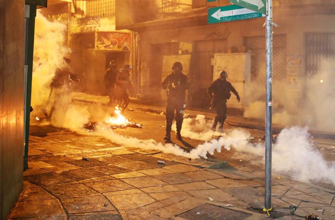 31 October 2019, Bolivia, La Paz: Police officers are standing in clouds of tear gas and smoke during clashes with demonstrators. Since the results of the presidential elections were announced, President Morales is confronted with accusations of manipul