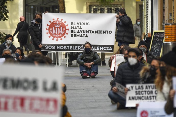 Trabajadores de la hostelería del barrio de Russafa realizan una sentada con una pancarta en la que se lee: `El virus mata. El Ayuntamiento remata para impedir la prohibición de las terrazas, en Valncia