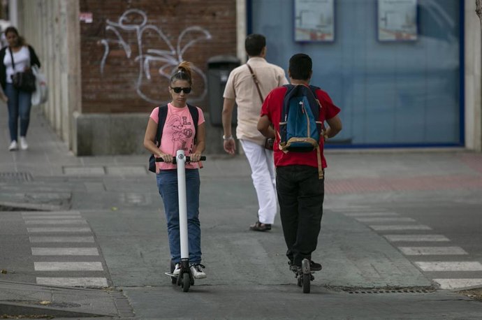 Personas circulando por el carril bici en patinete eléctrico.