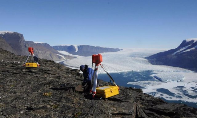 Un investigador (Leigh Stearns, Universidad de Kansas) ajusta una cámara de lapso de tiempo que monitorea el frente de Kangilliup Sermia (también conocido como Rink Isbrae), un glaciar de salida en Groenlandia.