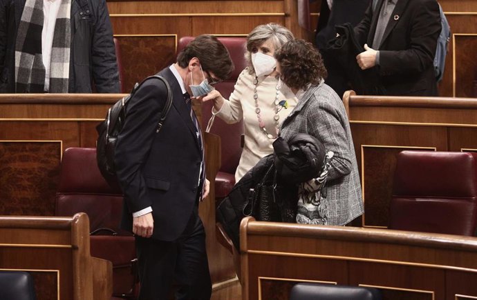 (I-D) El ministro de Sanidad, Salvador Illa, La exministra de Sanidad, Consumo y Bienestar Social, María Luisa Carcedo y la exministra de Trabajo, Magdalena Valerio mantienen una conversación durante una sesión plenaria en el Congreso de los Diputados, 