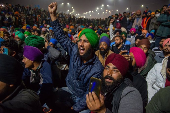 15 December 2020, India, Ghaziabad: Indian farmers listen to a speaker along a blocked highway during the ongoing sit-in protest at Singhu border against new agricultural laws. Photo: Pradeep Gaur/SOPA Images via ZUMA Wire/dpa