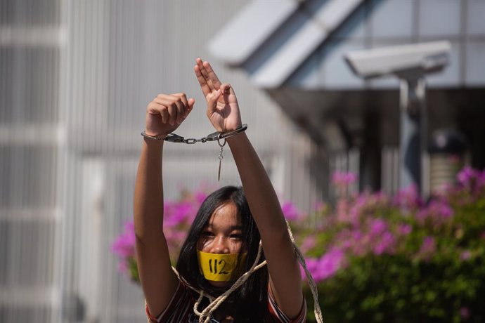 10 December 2020, Thailand, Bangkok: A protestor raises a three-finger salute with her hands in handcuffs during a rally to mark the constitution Day and International Human Rights Day. Photo: Varuth Pongsapipatt/SOPA Images via ZUMA Wire/dpa