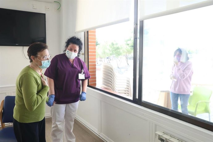Una residente se comunica con una familiar por una ventana de la Residencia Centro Casaverde Navalcarnero  durante el primer día de visitas en la desde que se cerró por el coronavirus. 