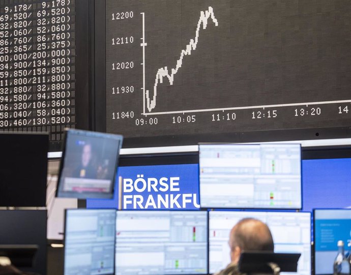 04 November 2020, Hessen, Frankfurt: A trader sits in the trading room of the Frankfurt Stock Exchange in front of the Dax curve and monitors which reports the US presidential election. Photo: Frank Rumpenhorst/dpa
