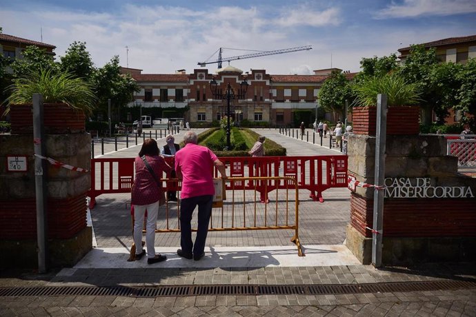 Una residente protegida con mascarilla de la Casa de Misericordia habla con dos familiares en el exterior del centro donde han habilitado una zona de visitas. En Pamplona (Navarra), a 2 de junio de 2020.