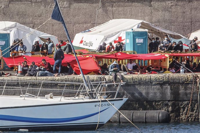 Varios inmigrantes en el Muelle de Arguineguín, en Gran Canaria, Canarias (España), a 18 de noviembre de 2020. Más de 2.300 migrantes permanecen hacinados en este muelle tras pernoctar en el campamento que se instaló el pasado mes de agosto en el recint