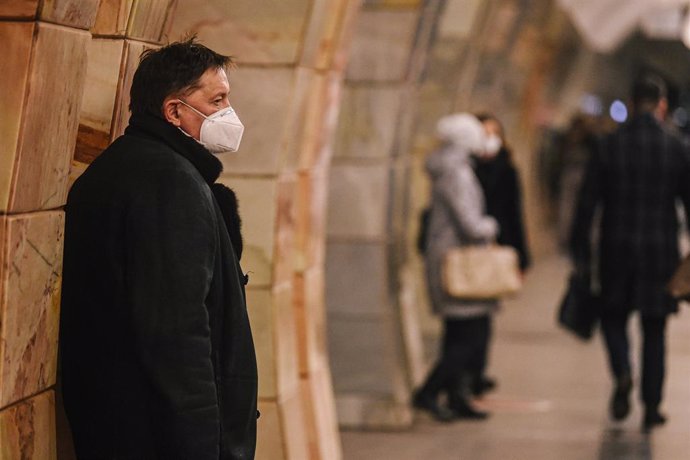 Un hombre con mascarilla esperando la llegada del metro en Moscú