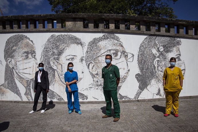 19 June 2020, Portugal, Porto: (L-R)Health workers Cristina Teixeira, Patricia Botelho, David Andrade, and Idalina Ramos, pose in front of a wall bearing their own portraits at Sao Joao hospital during the inauguration of the artwork by Portuguese arti