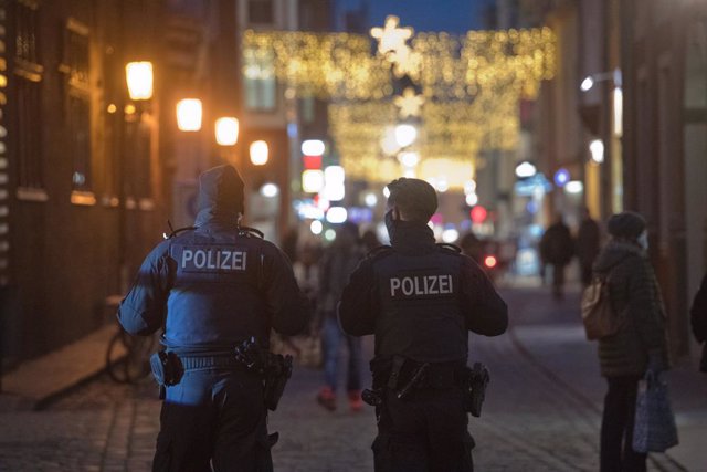 15 December 2020, Mecklenburg-West Pomerania, Stralsund: Police officers monitor compliance with the mask requirement on the shopping street and pedestrian zone of Ossenreyer Street, where passers-by are on their way to make purchases before the beginni