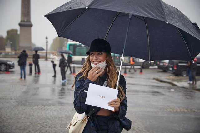 Una mujer con mascarilla y paraguas en París, Francia