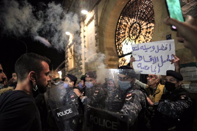19 December 2020, Lebanon, Beirut: Anti-government activists and university students face riot police during a demonstration due to the rise of tuition fees amid an acute economic crisis and political impasse engulfing the country. Photo: Marwan Naamani