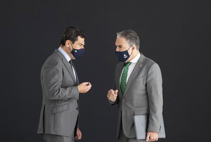 El presidente de la Junta de Andalucía, Juanma Moreno (i) y el consejero de la Presidencia, Elías Bendodo (d), conversan en los pasillos del Palacio de San Telmo.