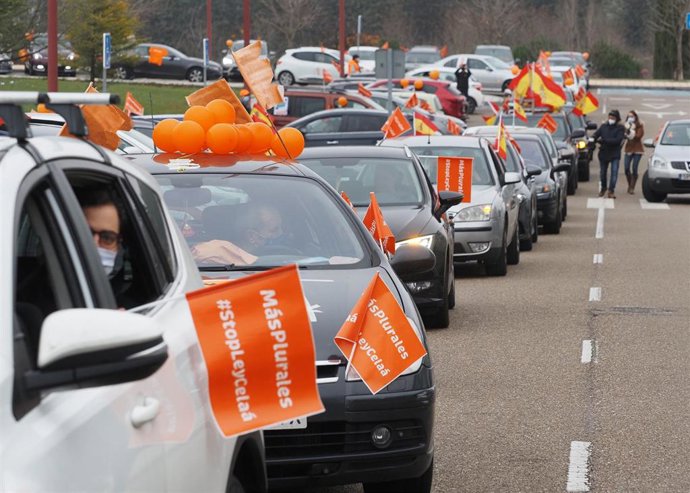 Varias personas circulan en coche en una concentración de vehículos contra la reforma educativa conocida como Ley Celaá, en Valladolid (España).